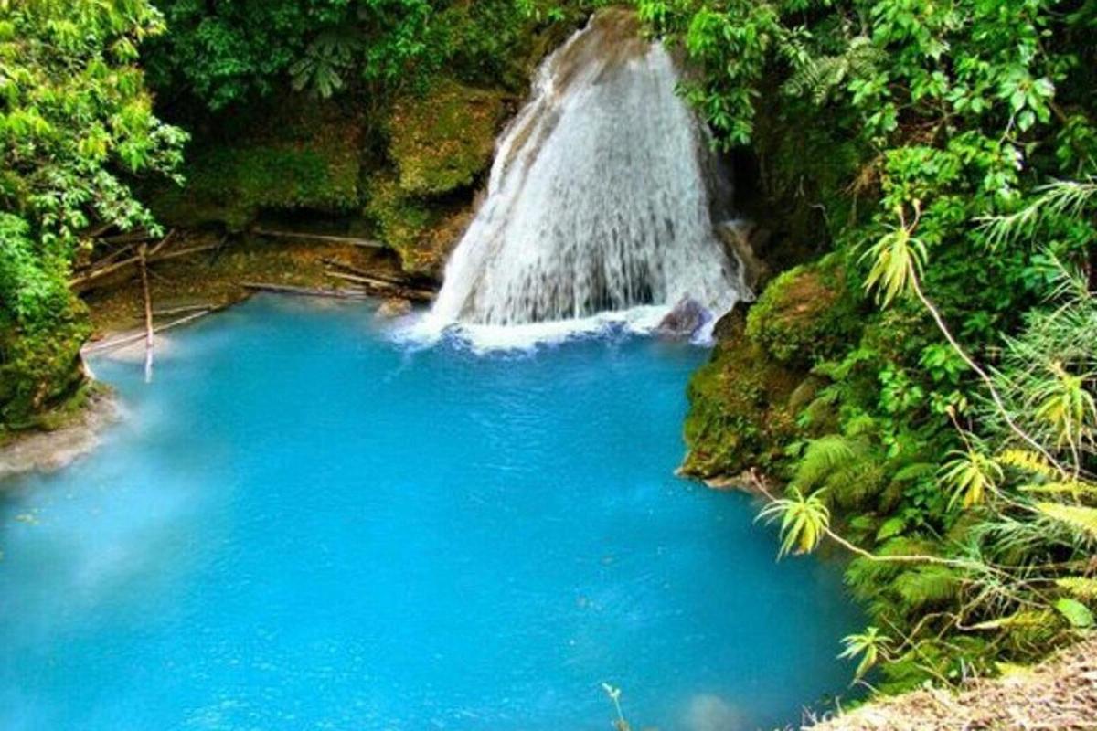 a waterfall in the middle of a blue pool of water