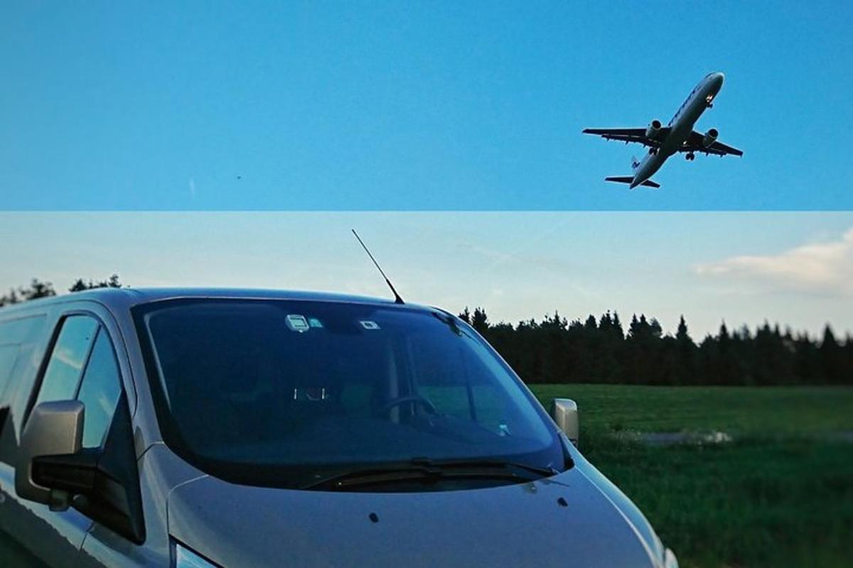 a car parked in a field with an airplane taking off