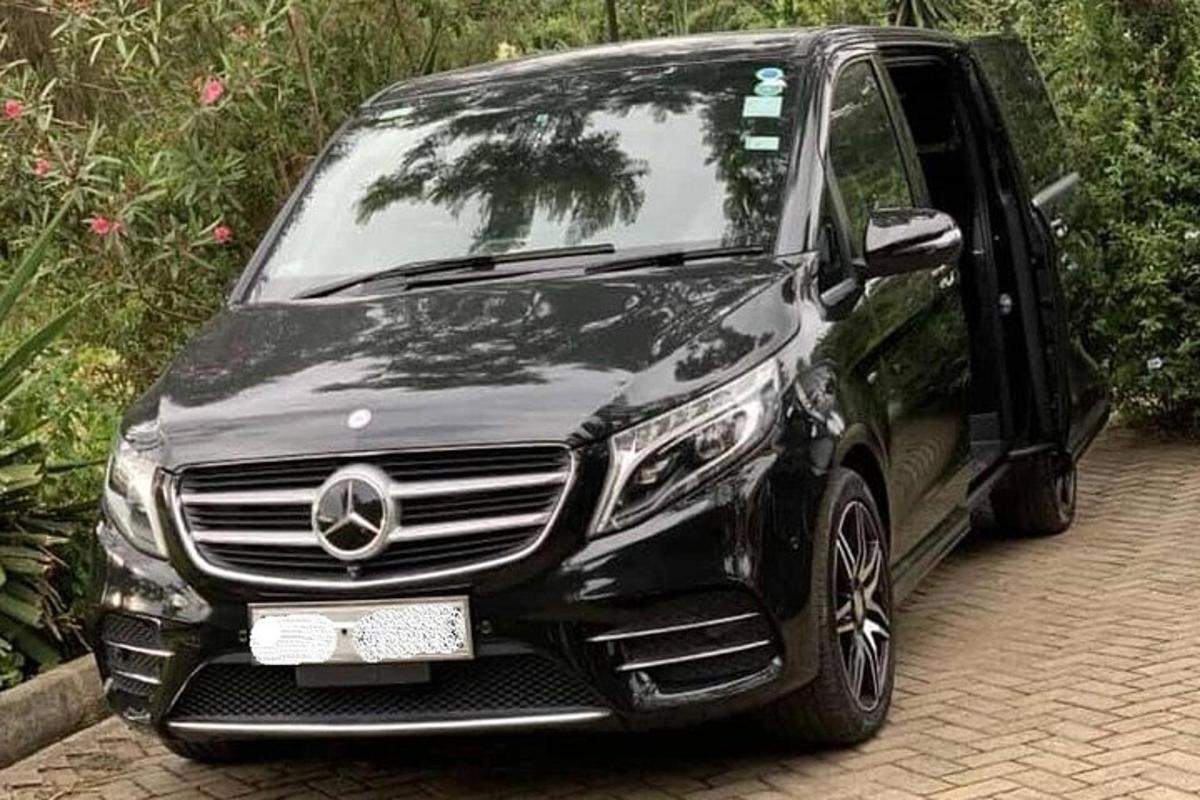 sebuah kereta mercedes benz hitam diletakkan di atas jalan batu