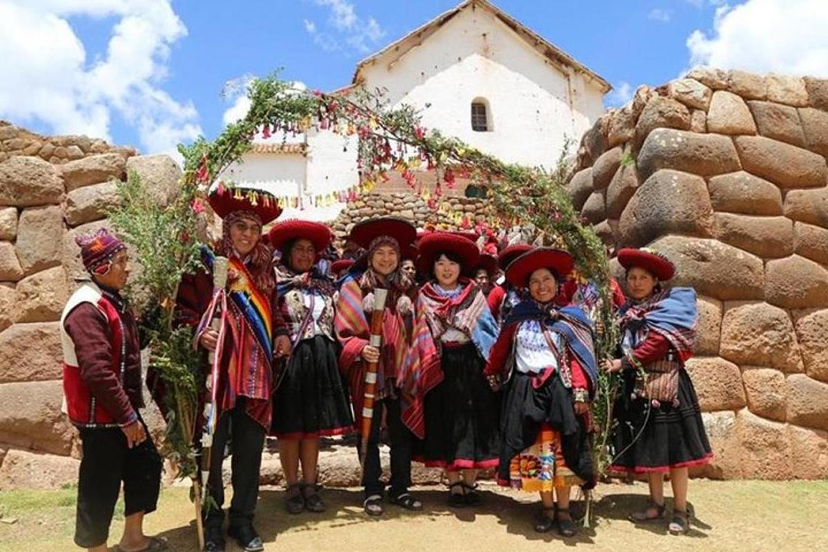 sekumpulan orang berpakaian tradisional berdiri di hadapan sebuah bangunan