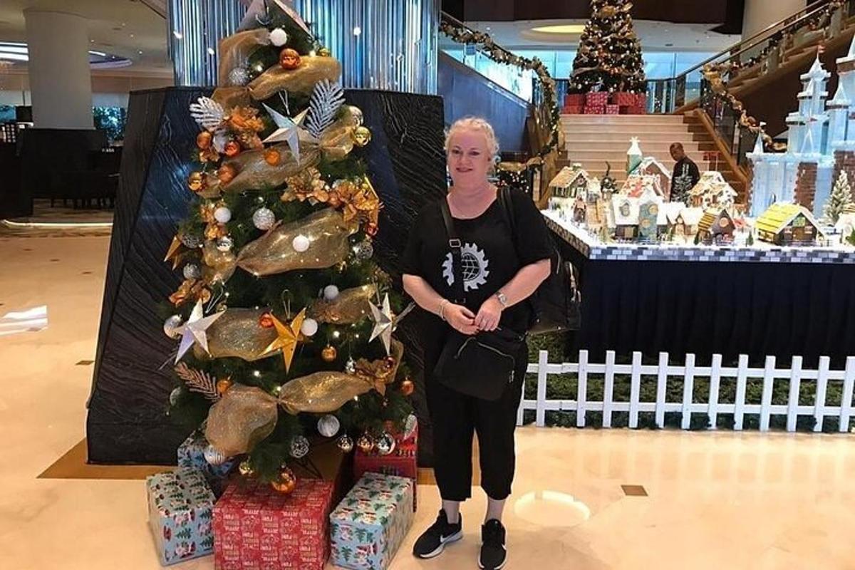 a woman standing next to a christmas tree in a store
