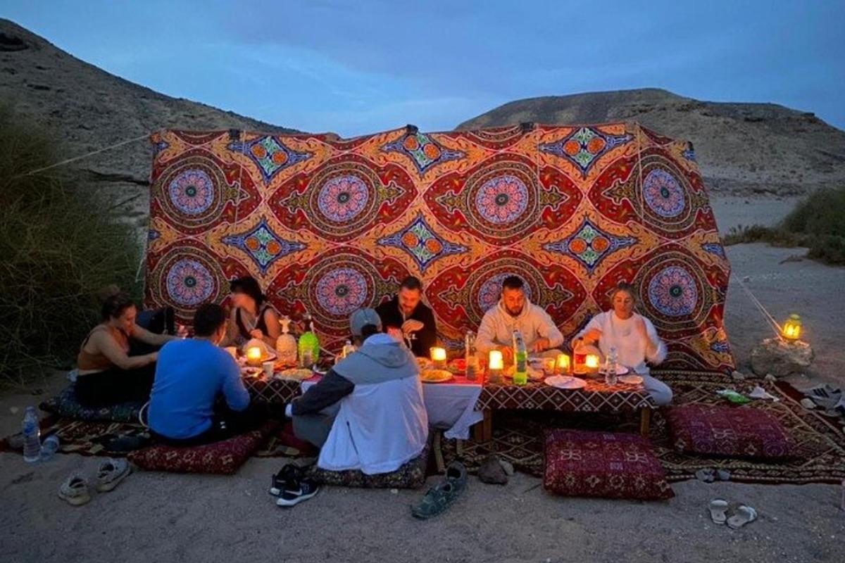 um grupo de pessoas sentadas ao redor de uma mesa com velas