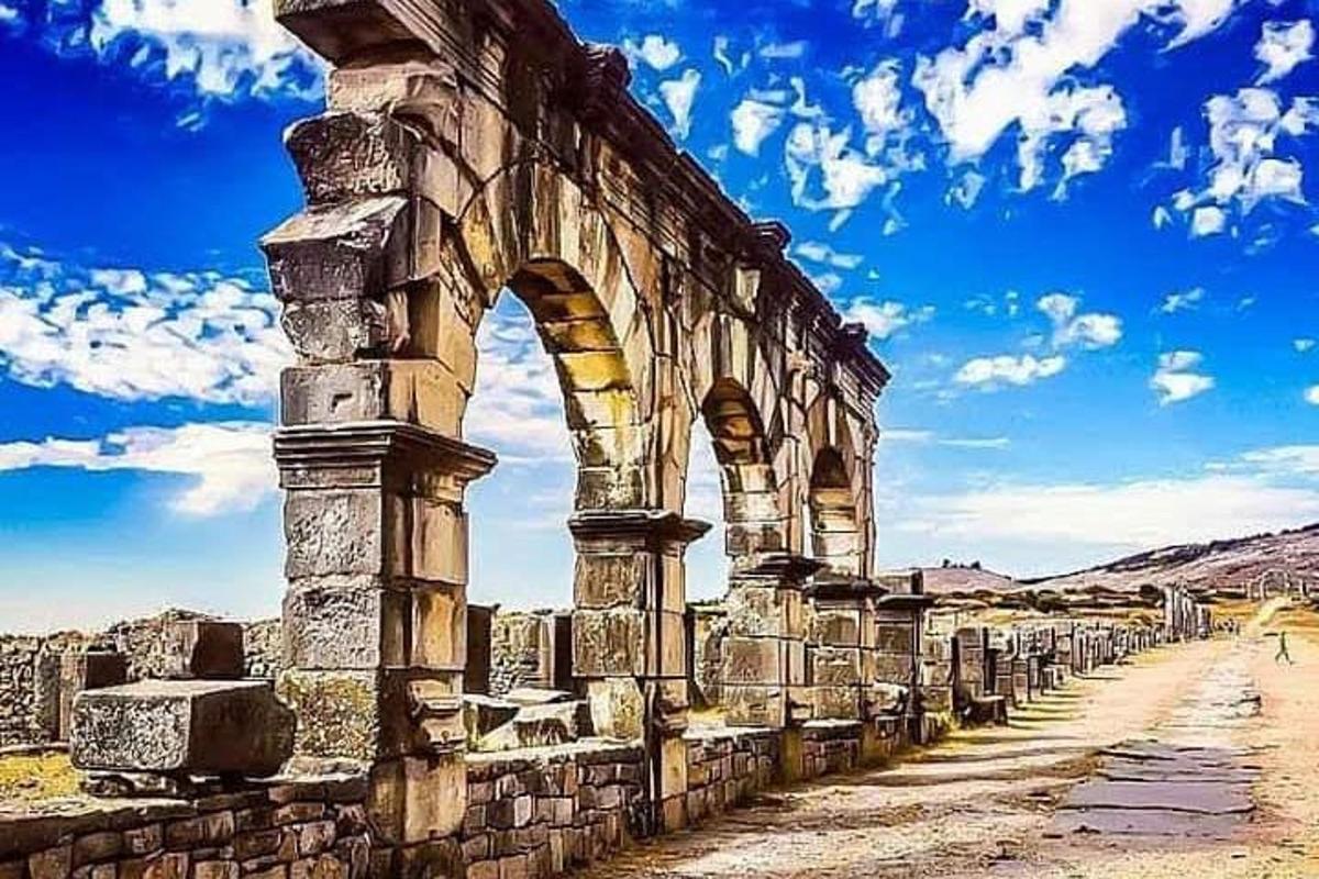 an ancient building with an arch in the desert