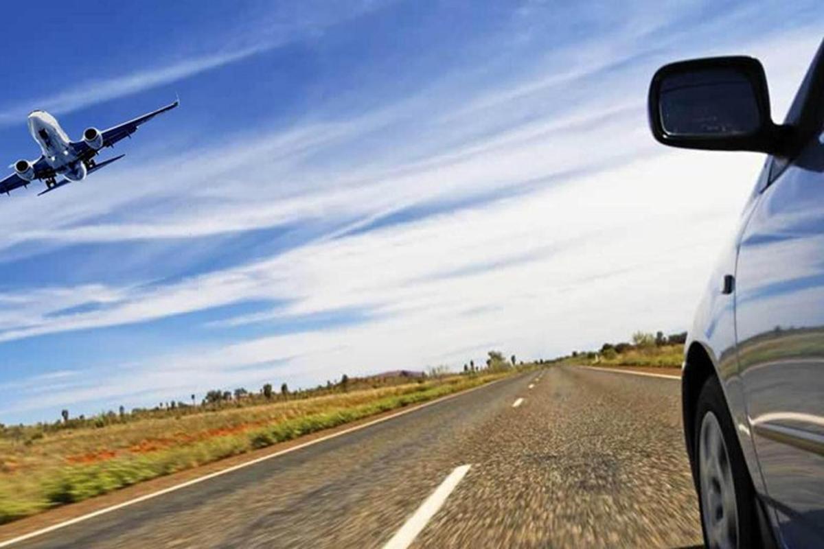 一架飞机和一辆汽车一起飞过公路
