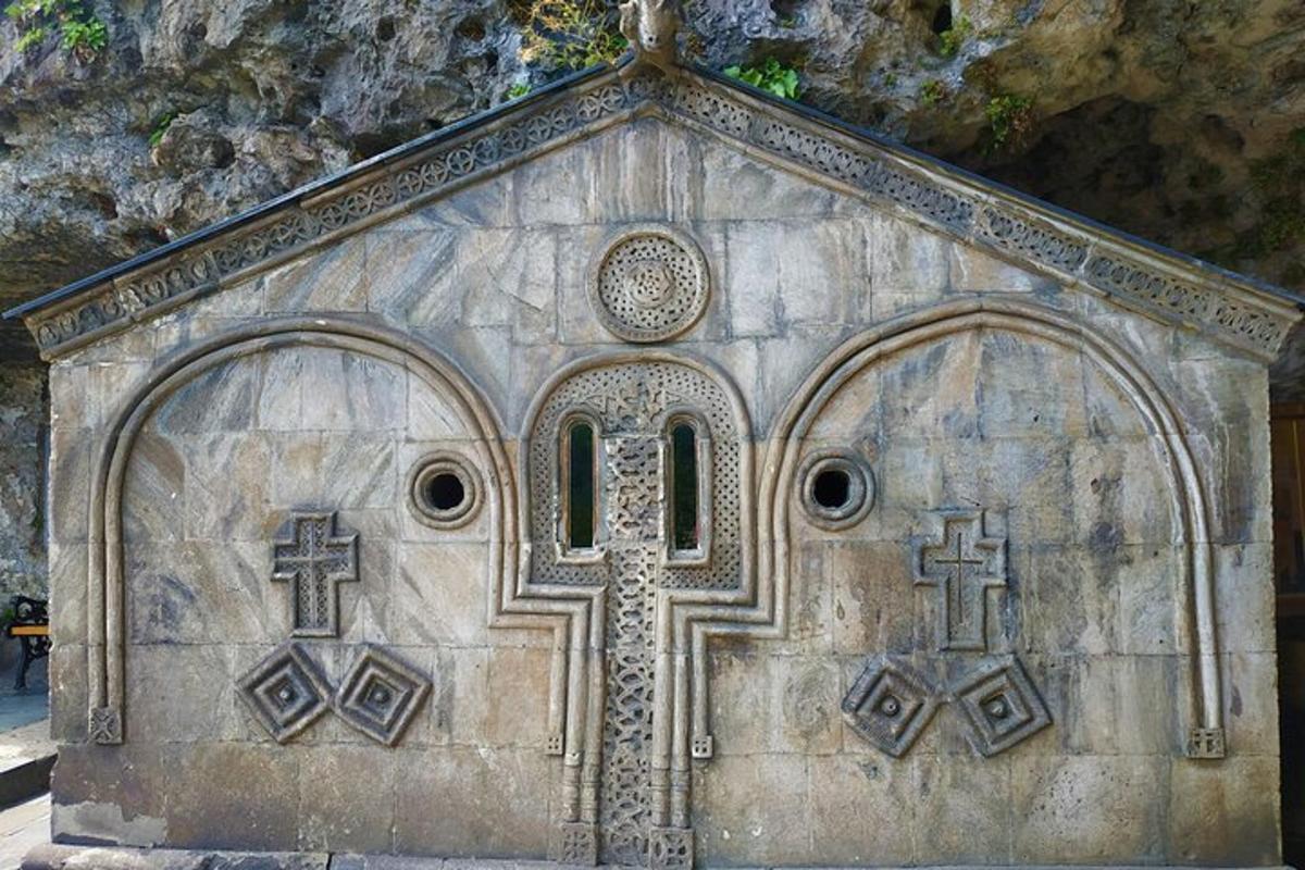 una iglesia de piedra con dos cruces y una ventana