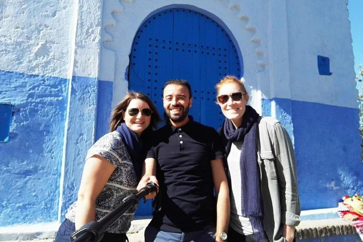 tre persone in piedi davanti a un edificio blu