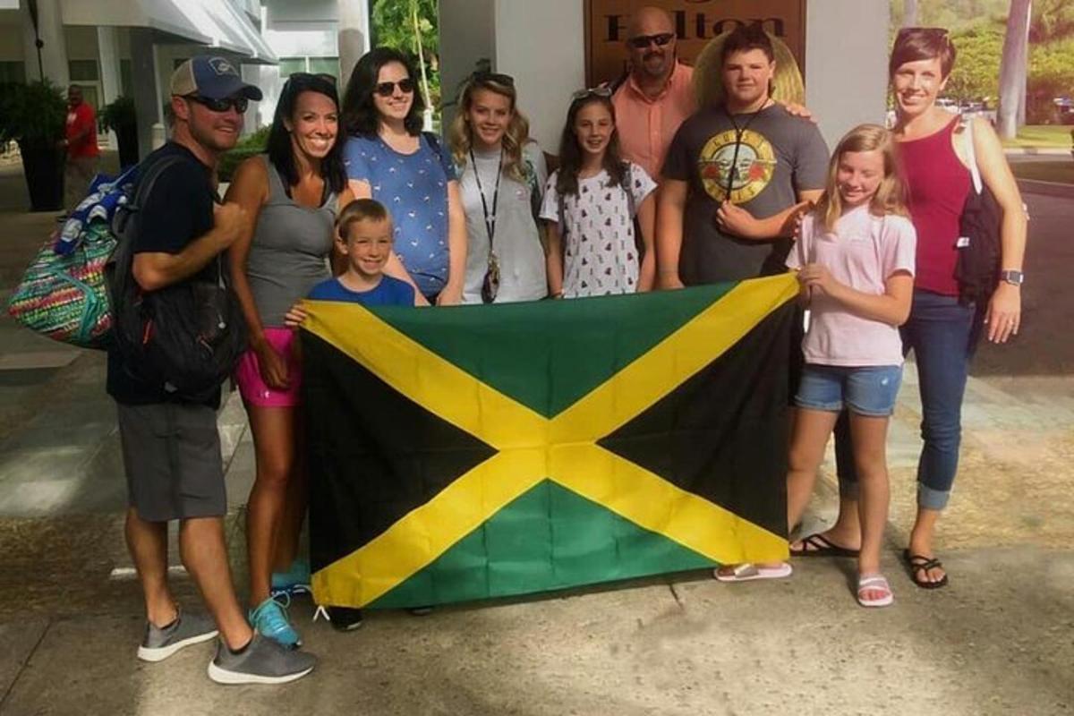 un gruppo di persone in posa per una foto con una bandiera
