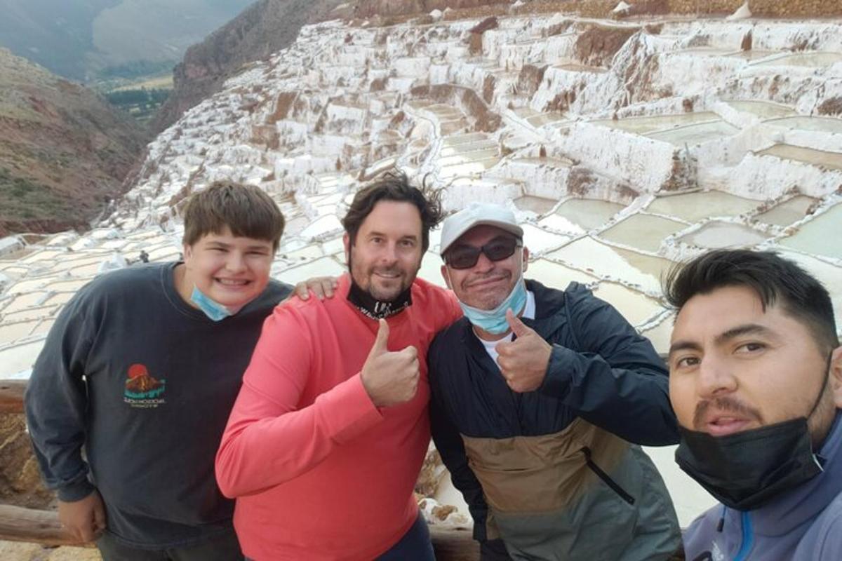 un gruppo di tre uomini che fanno il gesto del pollice in su su una montagna