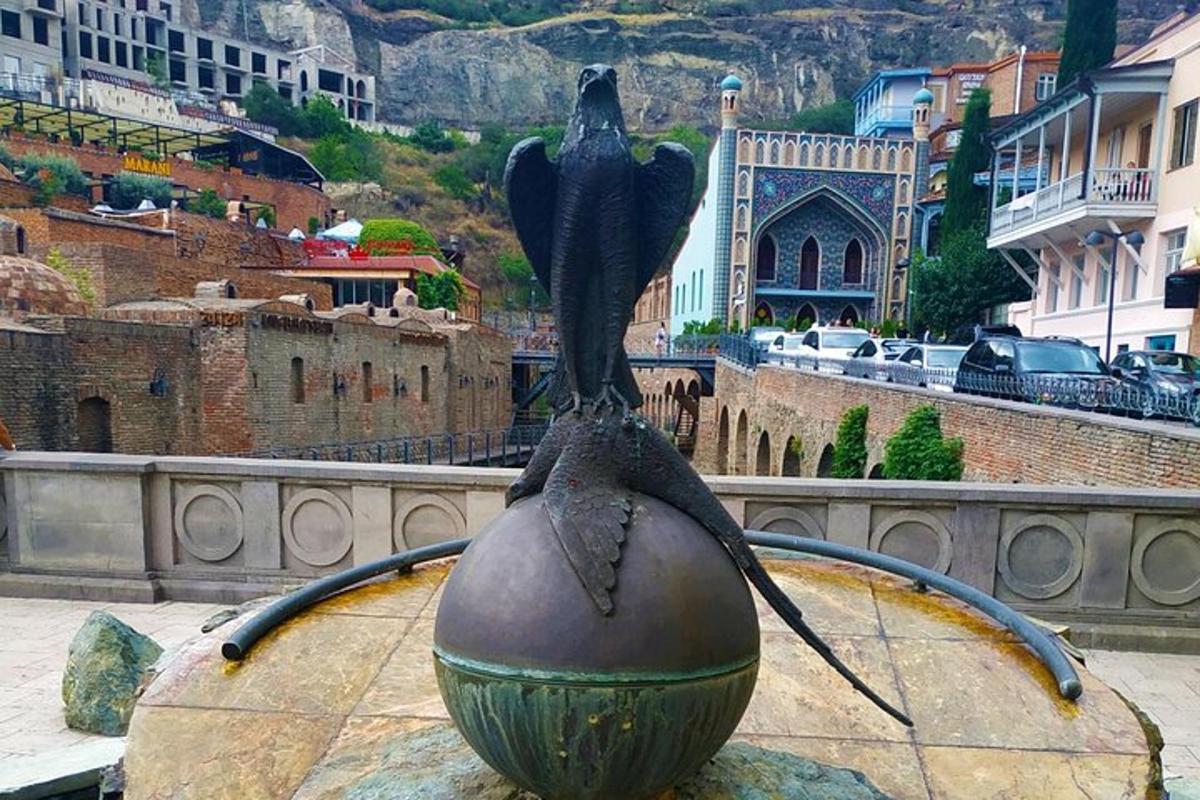 una estatua de un pájaro sentado encima de una pelota
