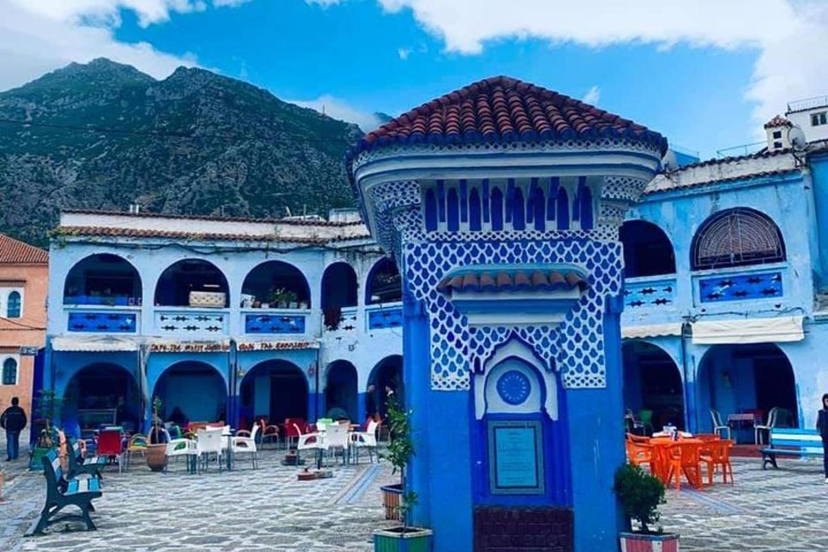 um prédio azul em um pátio com mesas e cadeiras