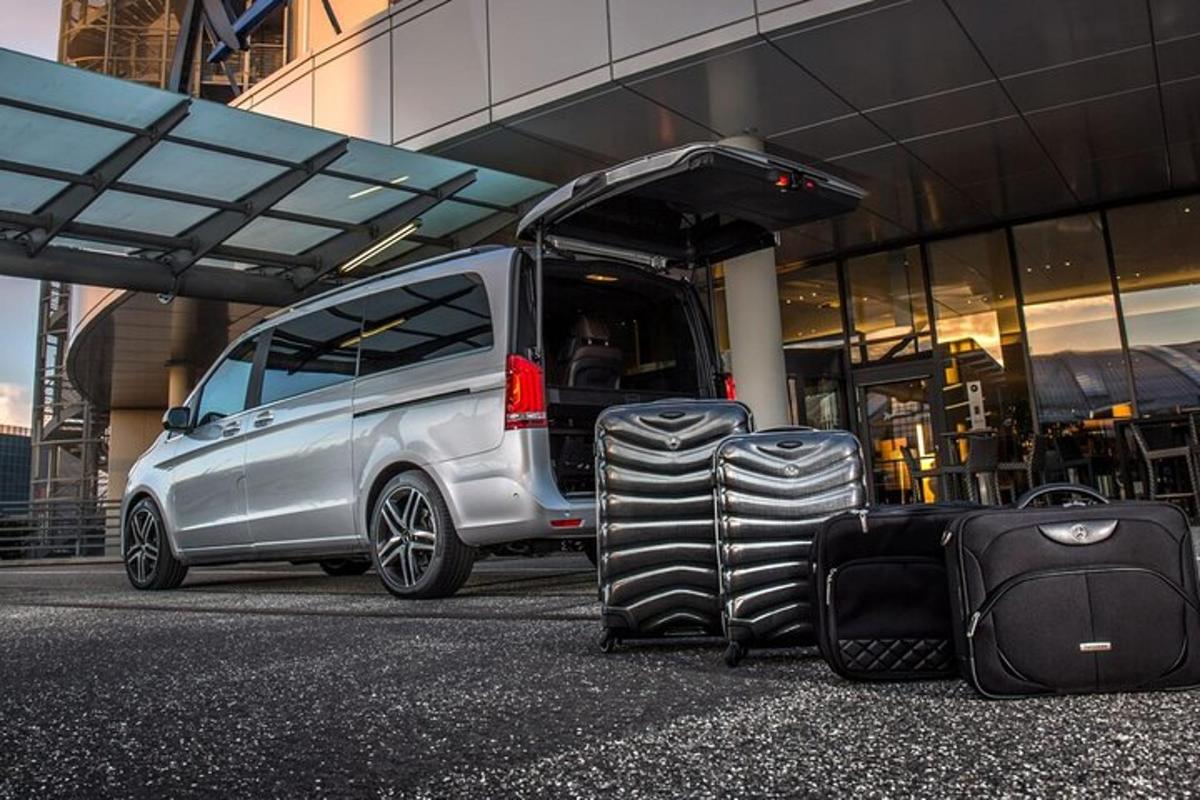a silver van with luggage next to a building