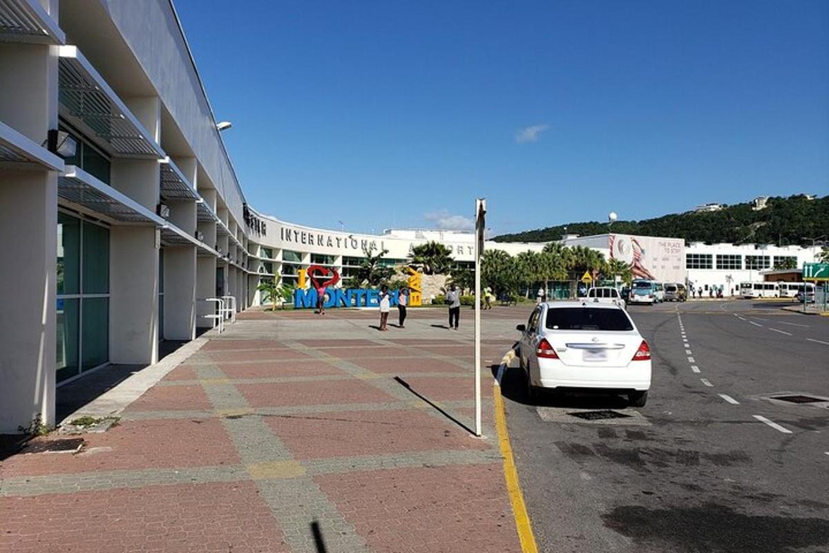 bel avto parkiran na parkirišču poleg stavbe