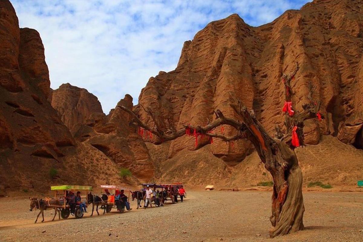 a group of people on horse drawn carts in front of a mountain