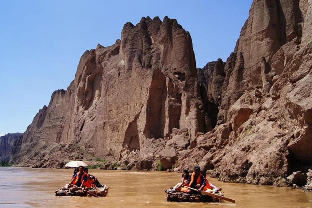 a group of people riding down a river on canoes