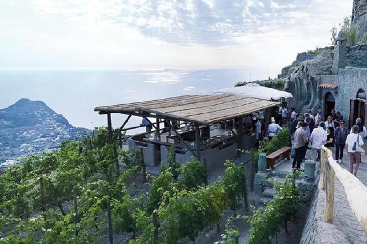 Un grupo de personas paradas afuera de un edificio en una montaña.
