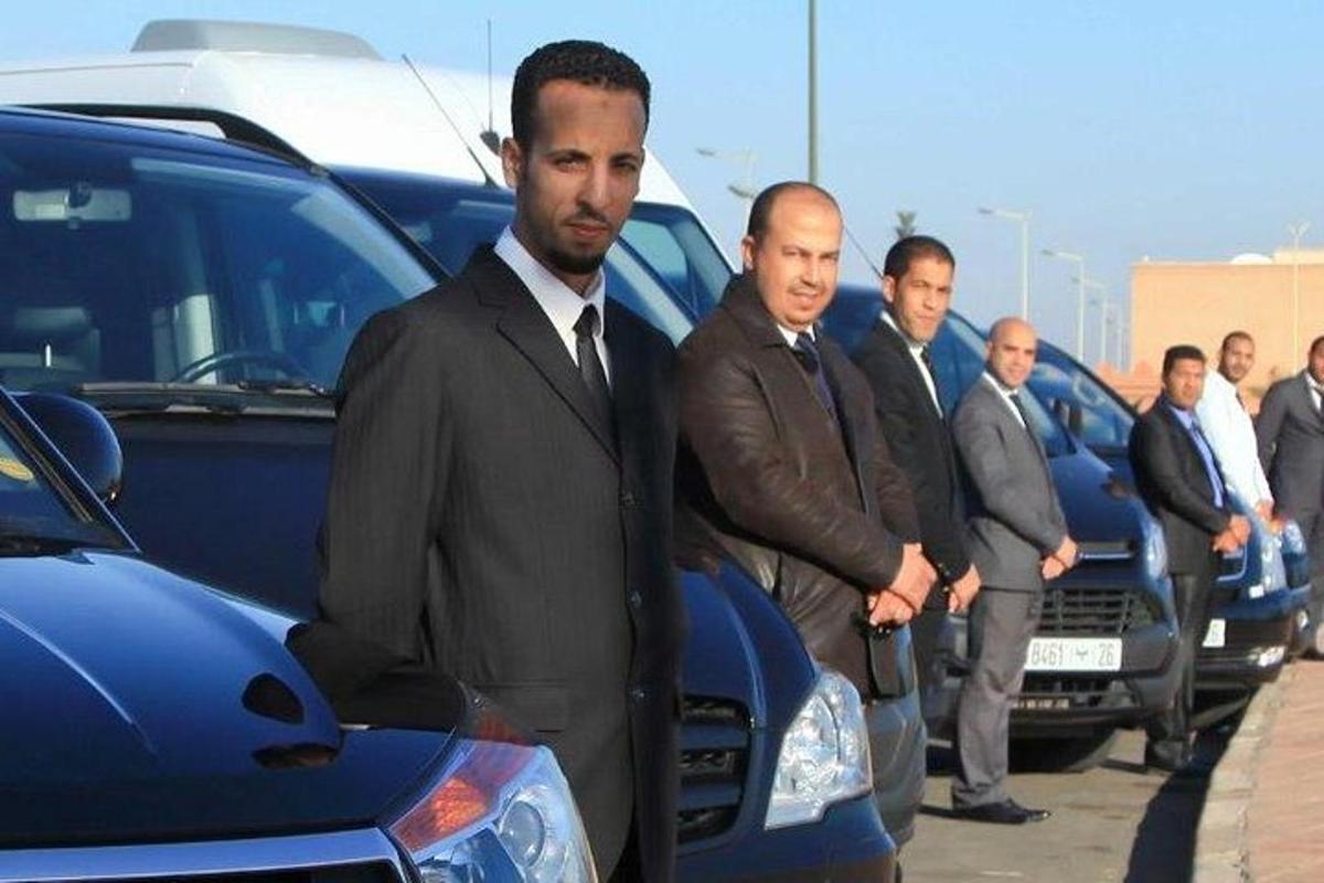 eine Gruppe von Männern steht vor Autos