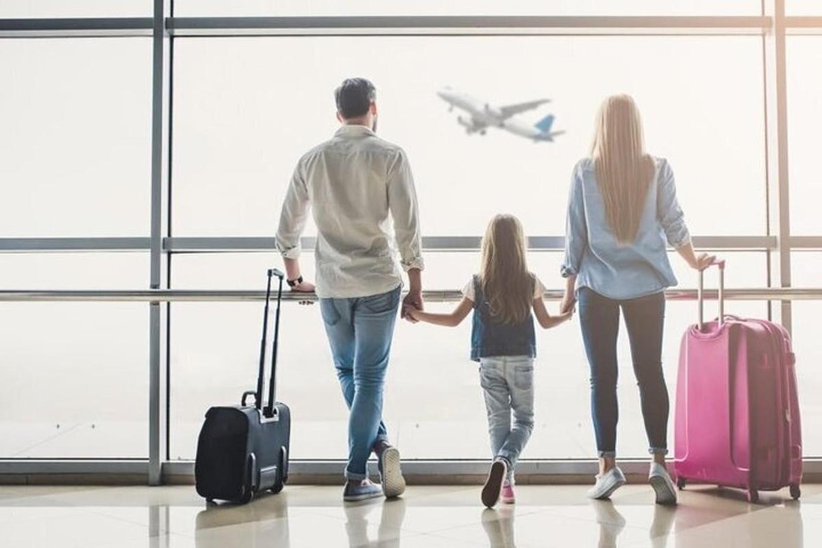 uma família caminhando por um aeroporto com bagagem