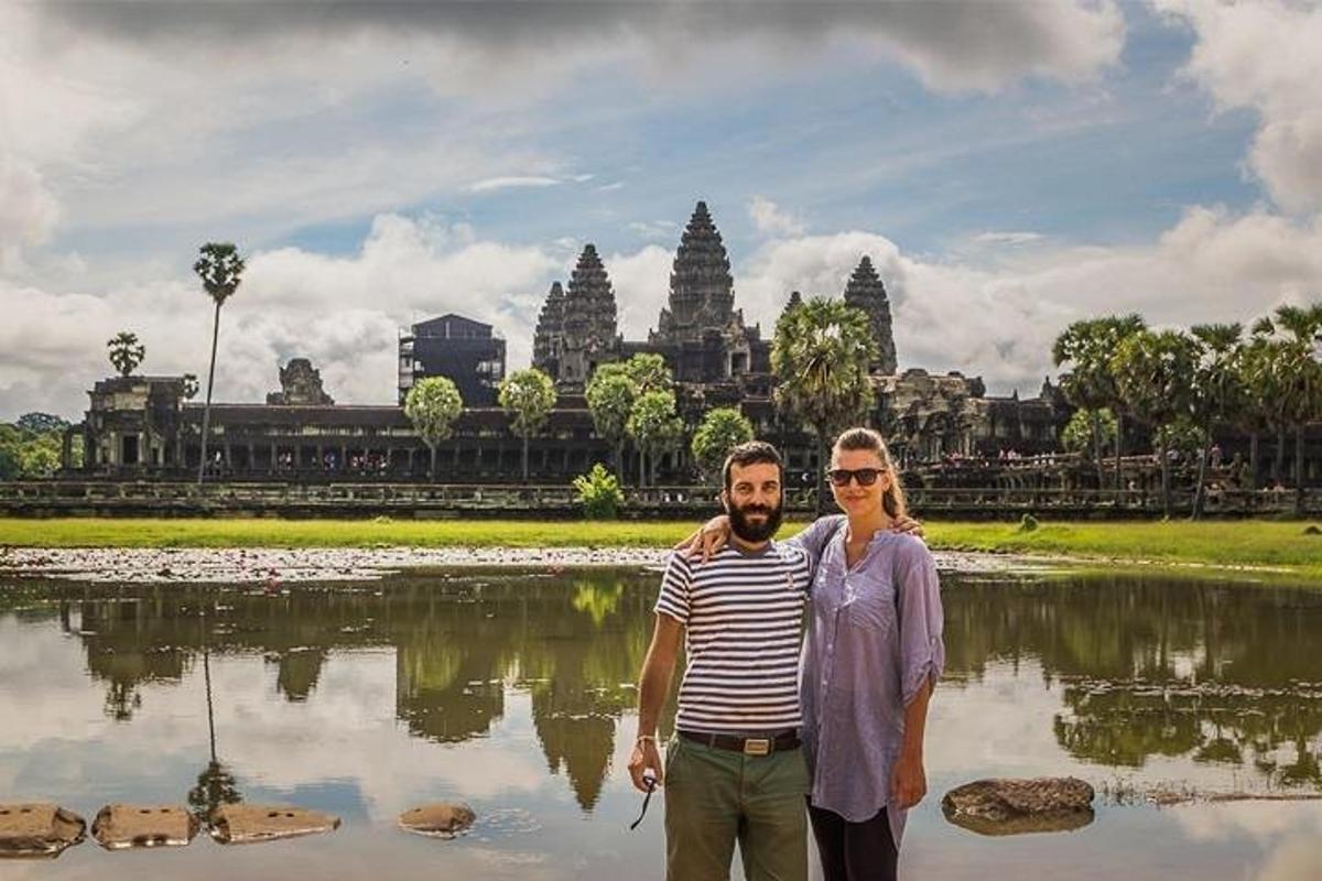 a man and a woman standing in front of a lake