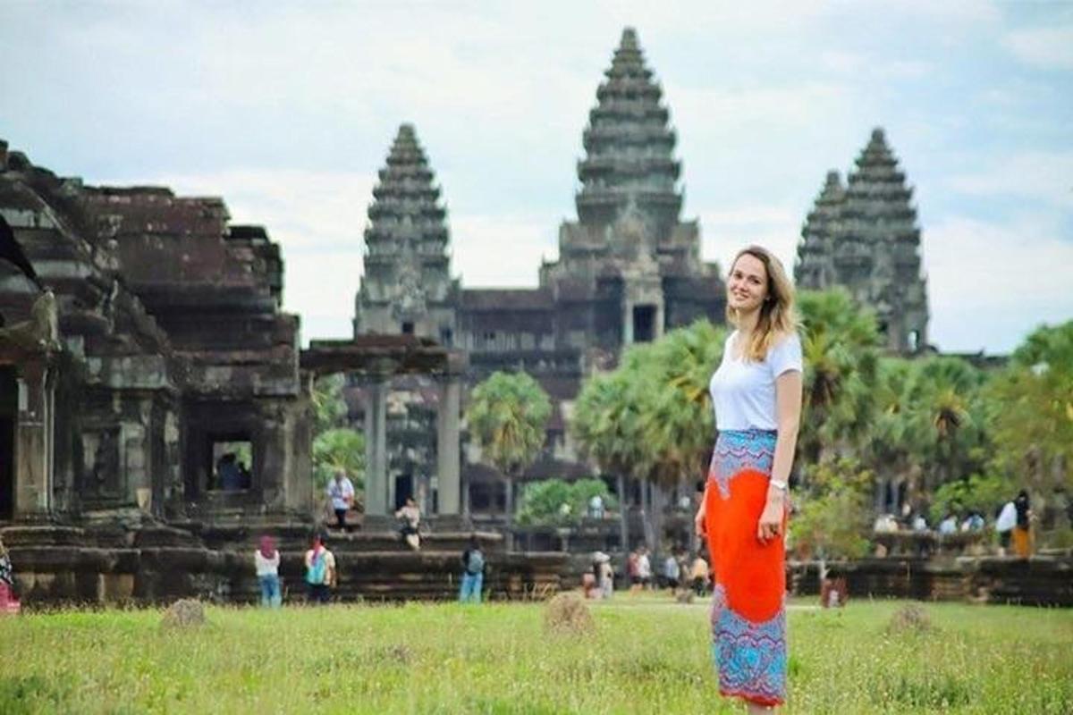 seorang wanita berdiri di depan kuil