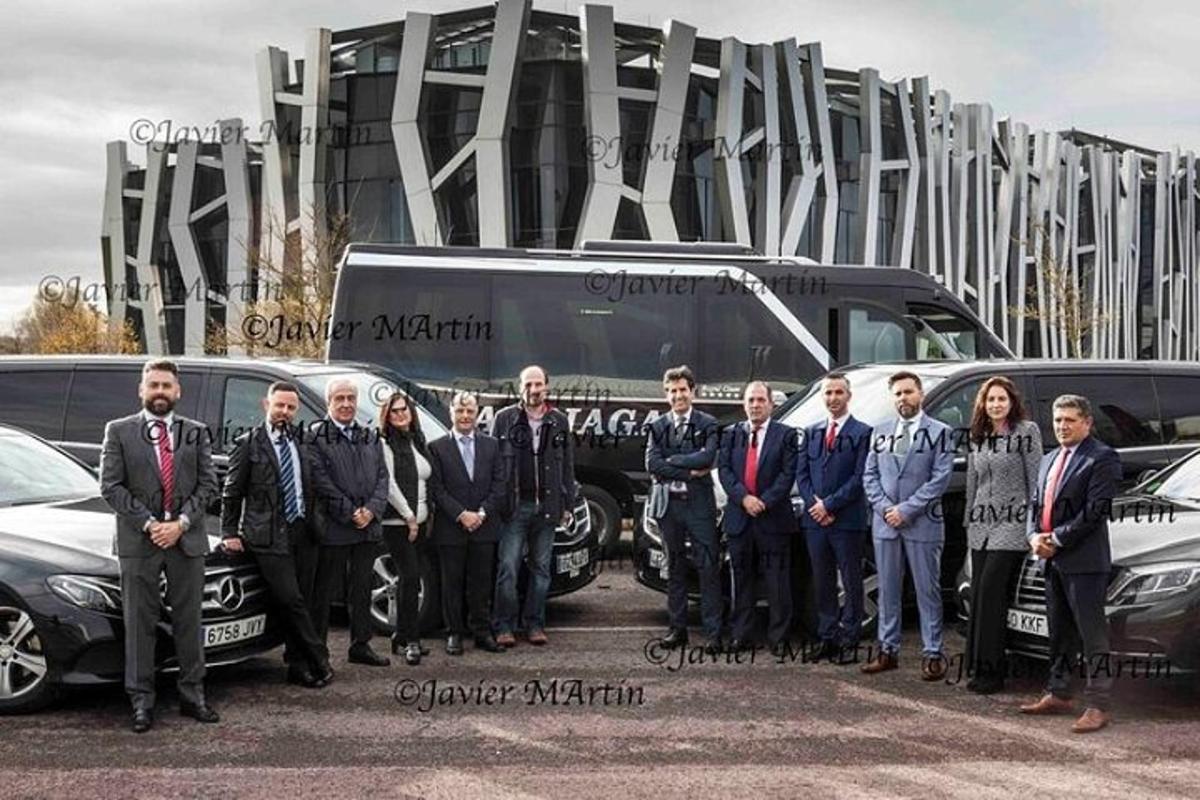un grup de persones dretes davant d'un autobús