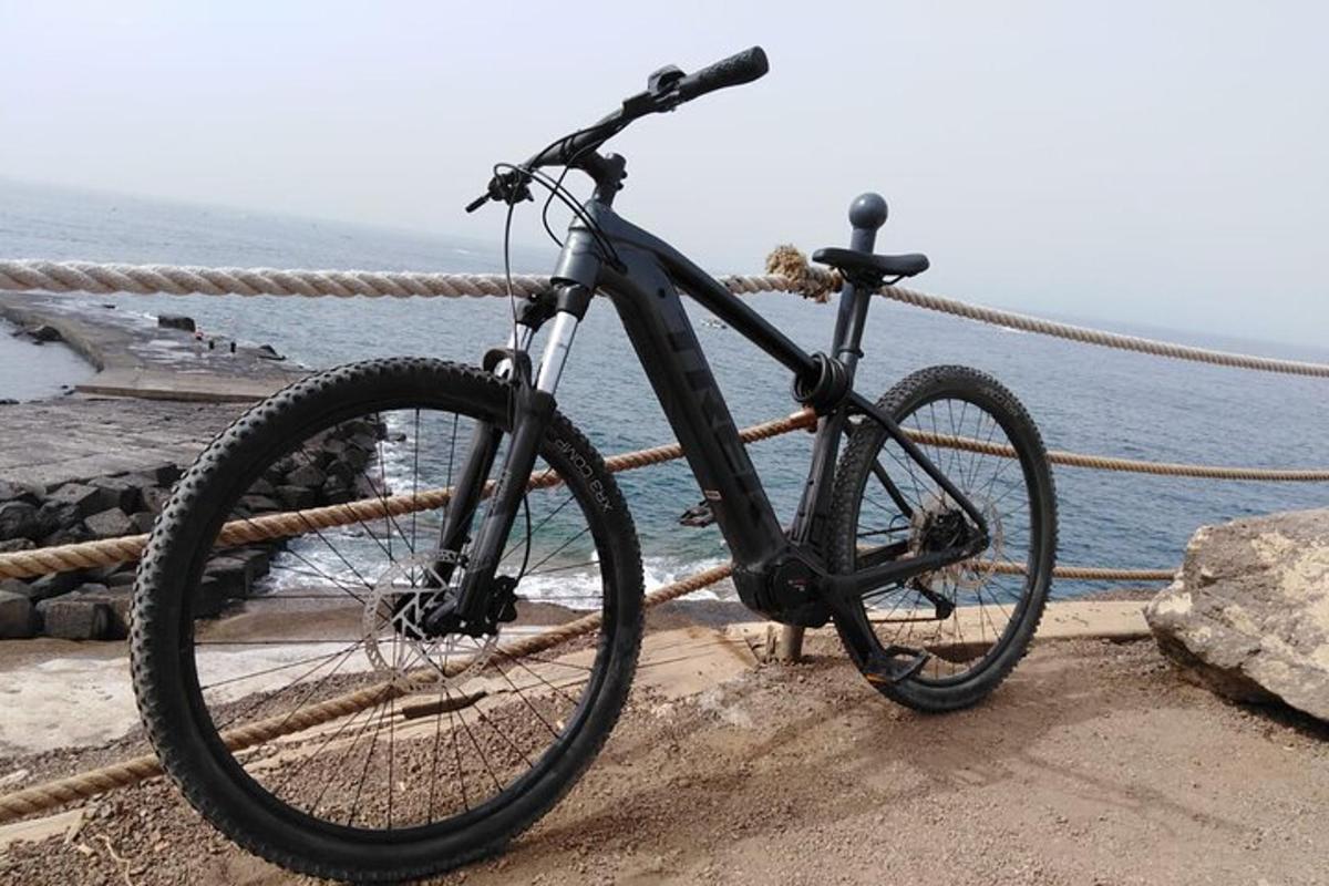 a black bike parked on a railing near the water