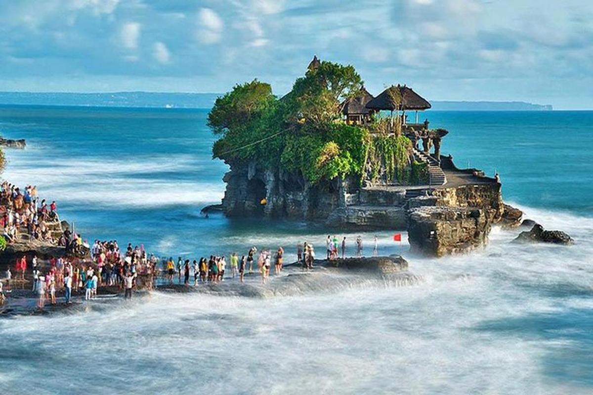 isang grupo ng mga tao na nakatayo sa isang bato sa karagatan