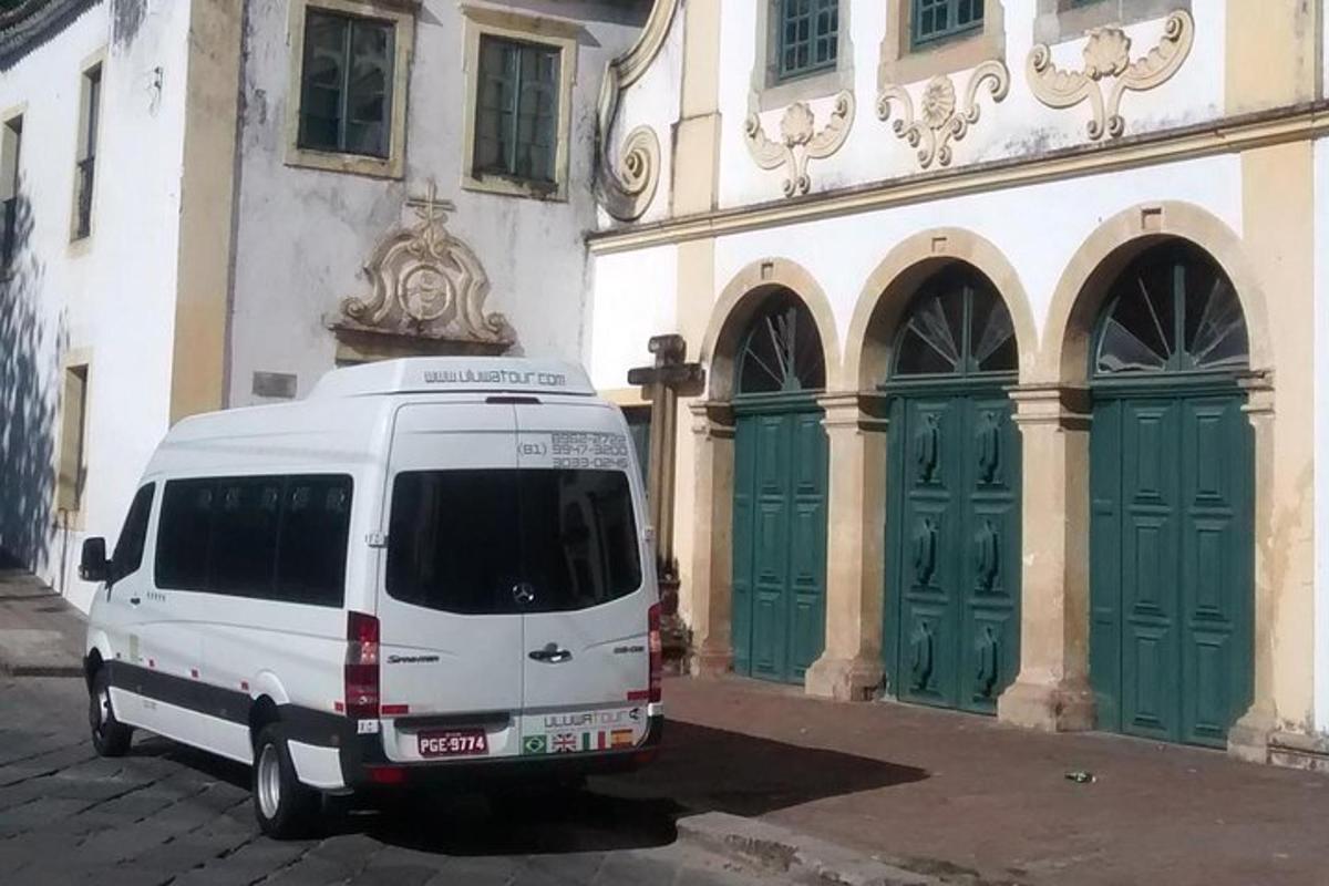 a white van parked in front of a building with green doors
