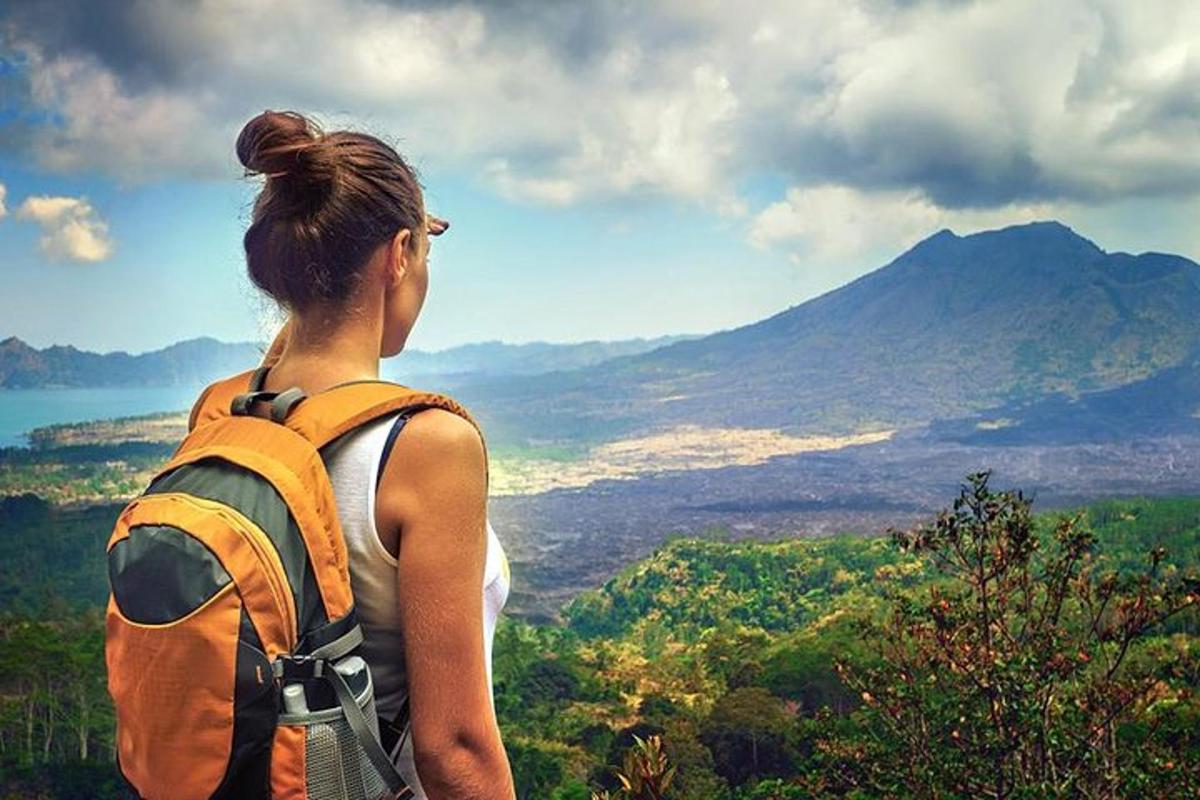 uma mulher com uma mochila olhando para uma montanha