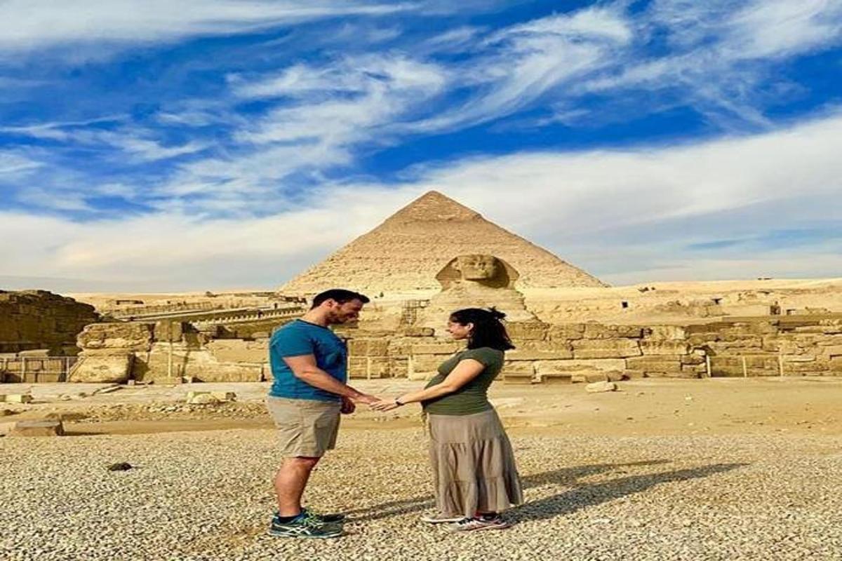 muž a žena stojící před pyramidami