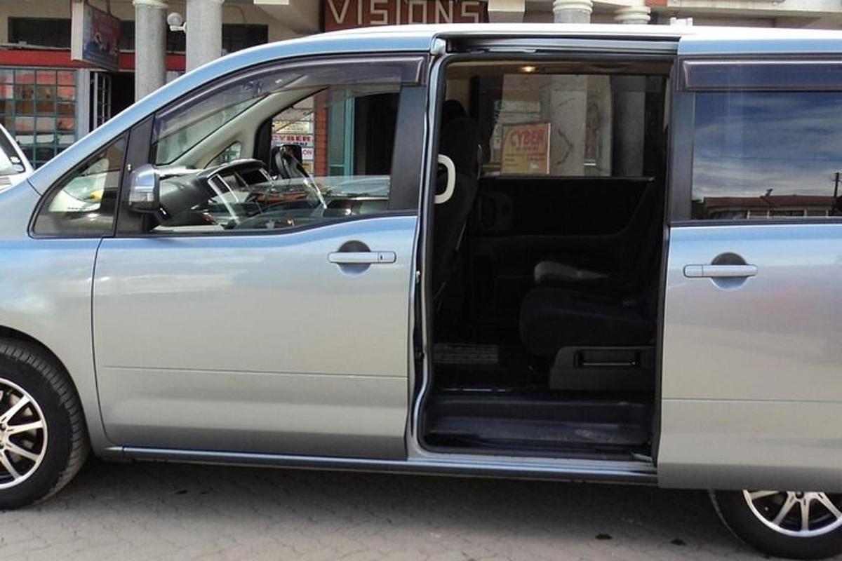 un furgone argentato con la portiera aperta su una strada