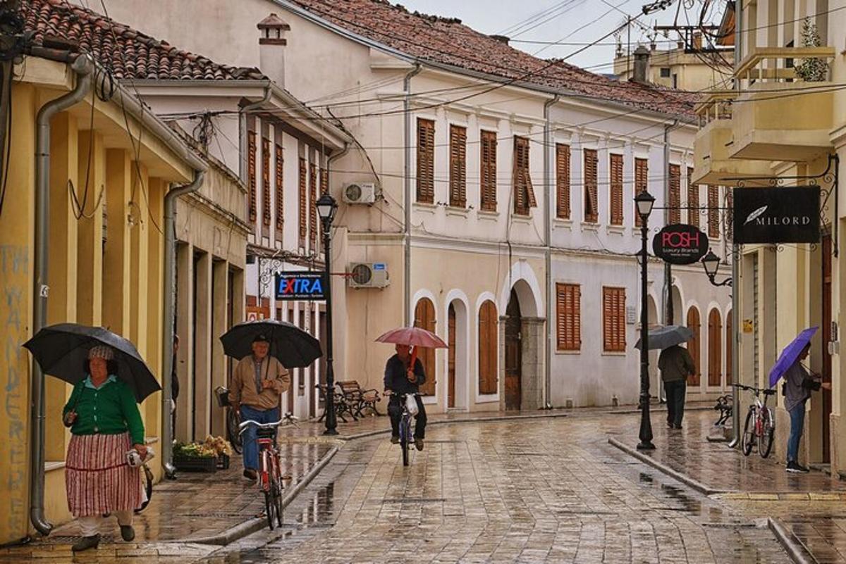 skupina lidí jdoucích po ulici s deštníky