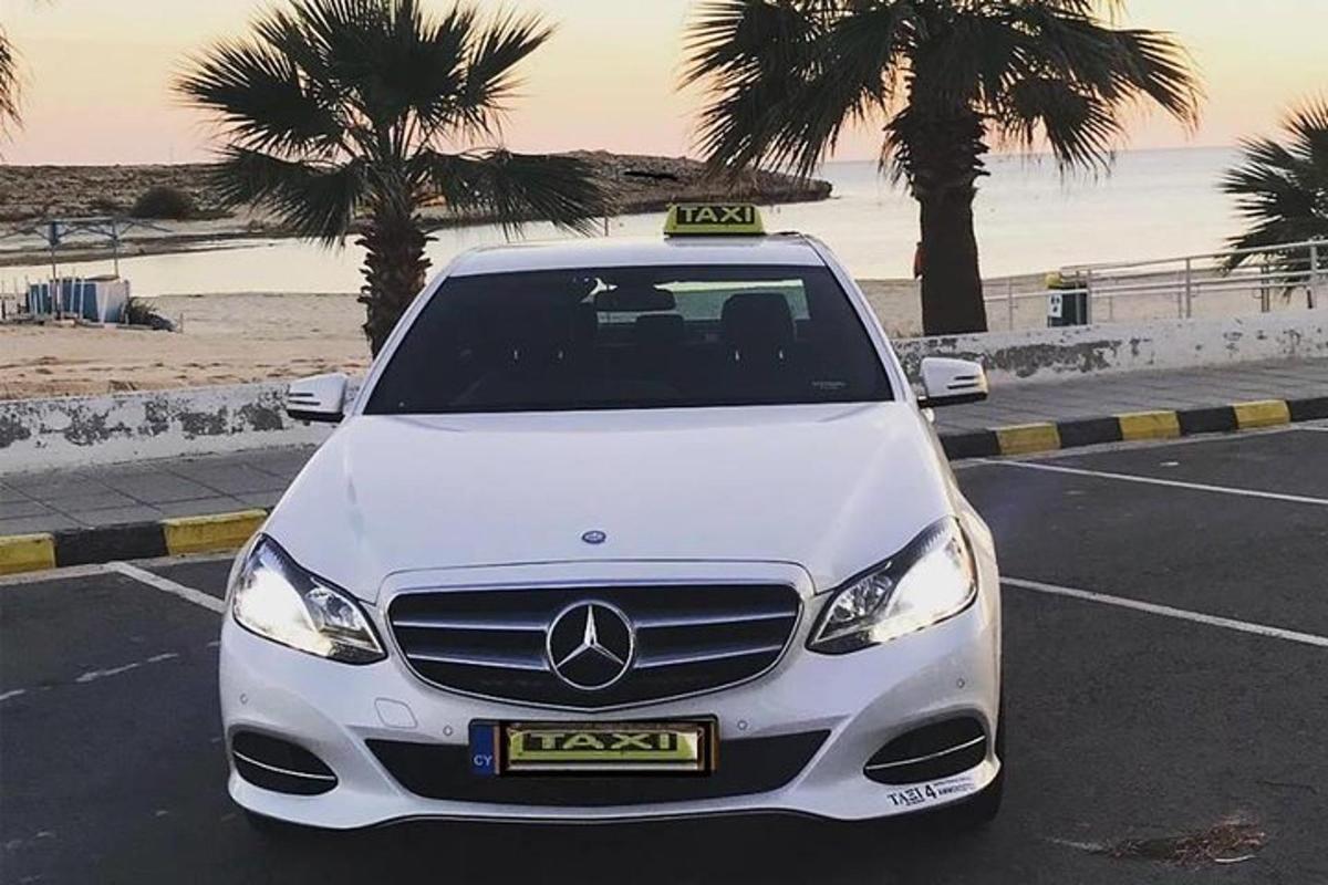 a white car parked in a parking lot near the beach
