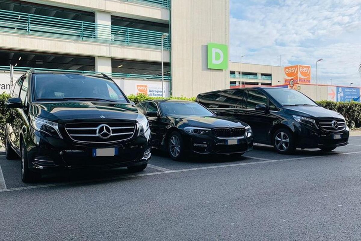 tres cotxes aparcats en un aparcament davant d'un edifici