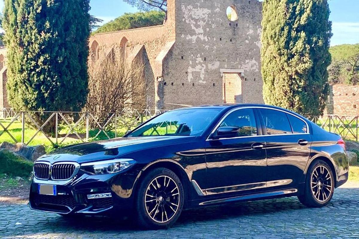 un cotxe BMW blau aparcat davant d'un castell