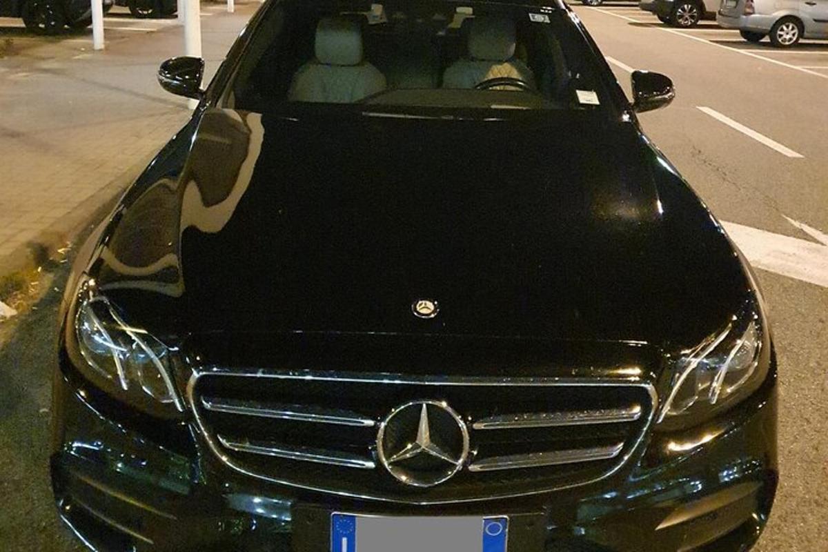 Un automóvil Mercedes Benz estacionado al costado de una calle.