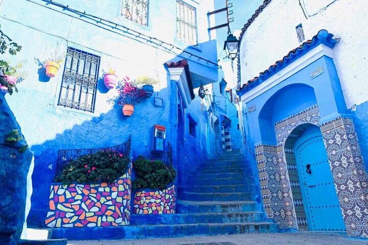 Un edificio azul con escaleras y una puerta azul.
