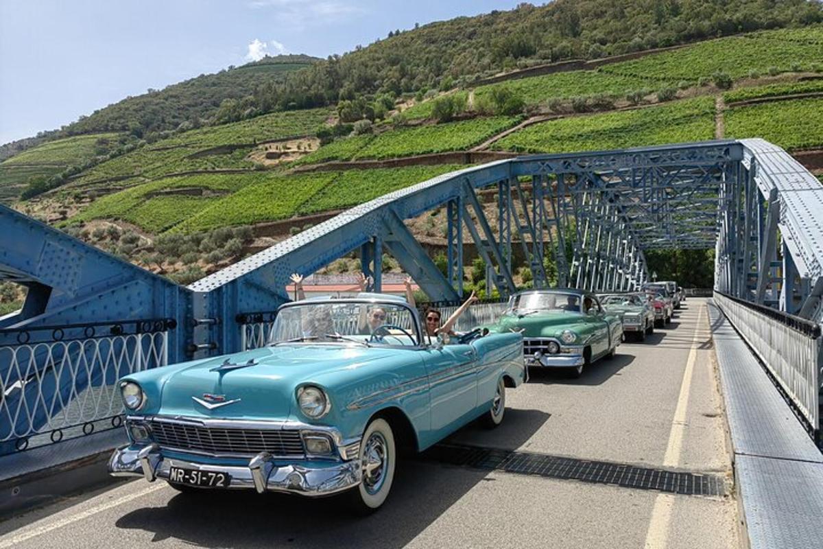a group of old cars parked on a bridge