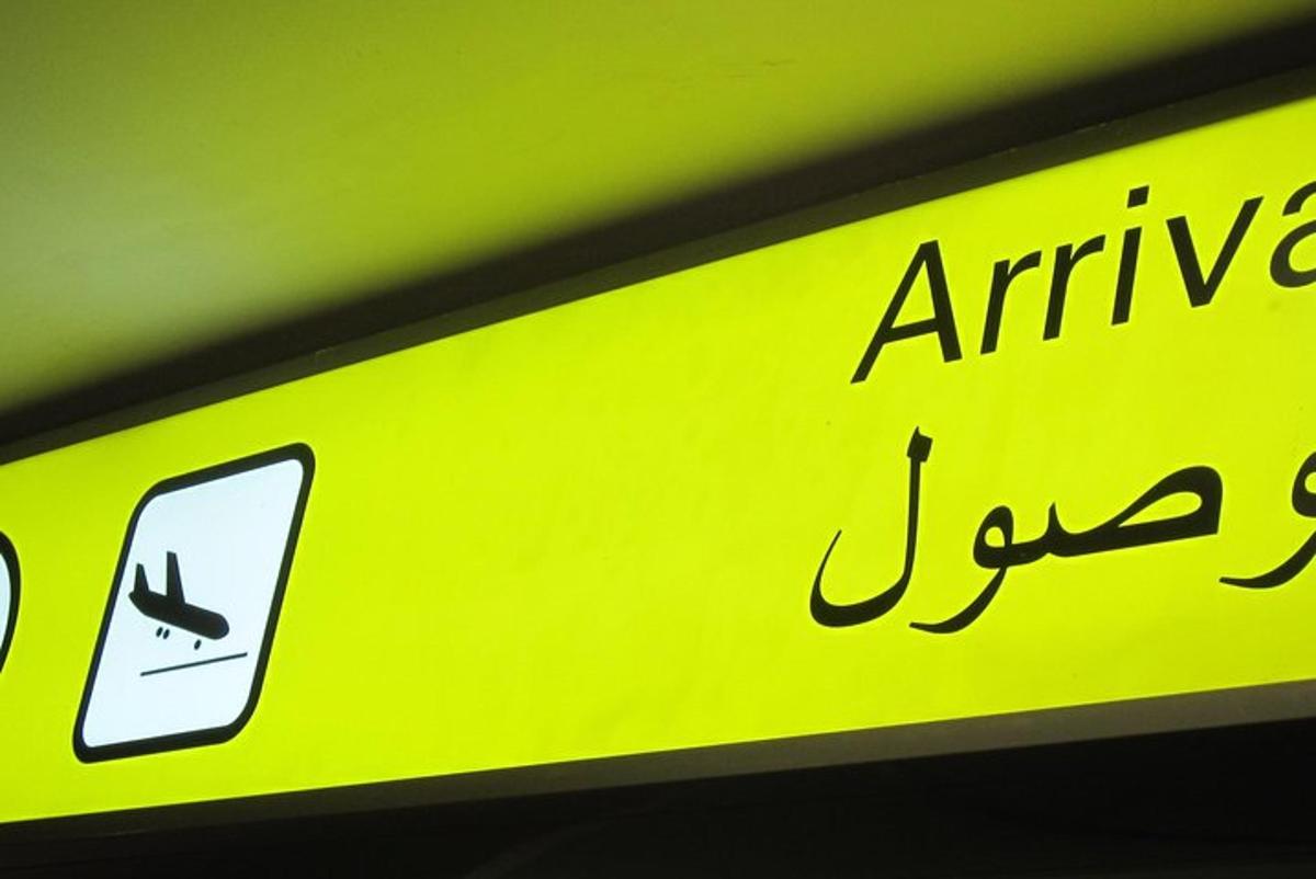 a yellow sign with an arrow and a cell phone
