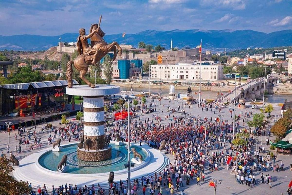 una grande folla di persone in una città con una statua