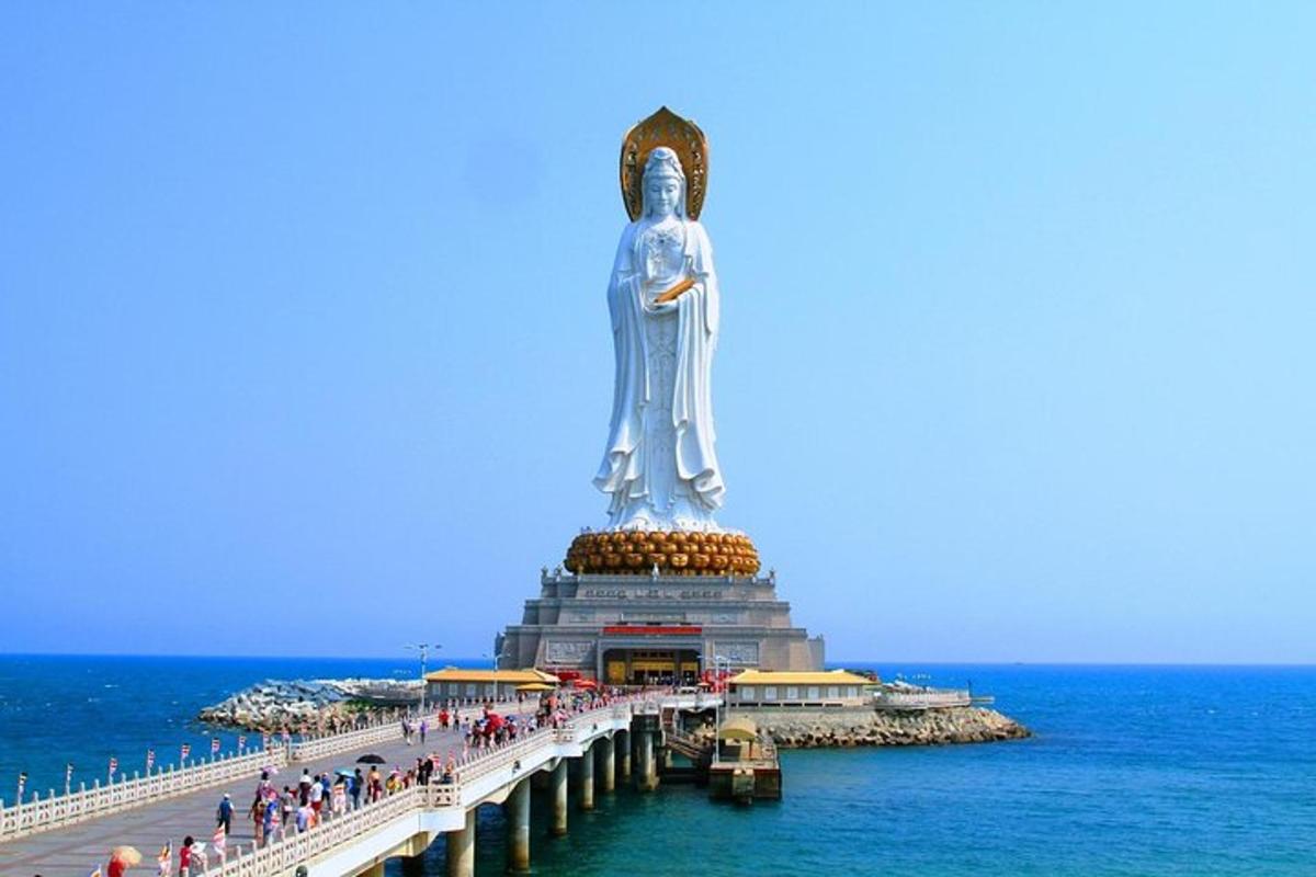 a statue on a pier next to the ocean
