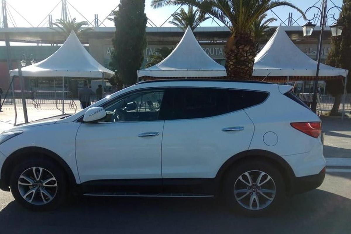 un cotxe blanc aparcat en un aparcament amb dues tendes blanques