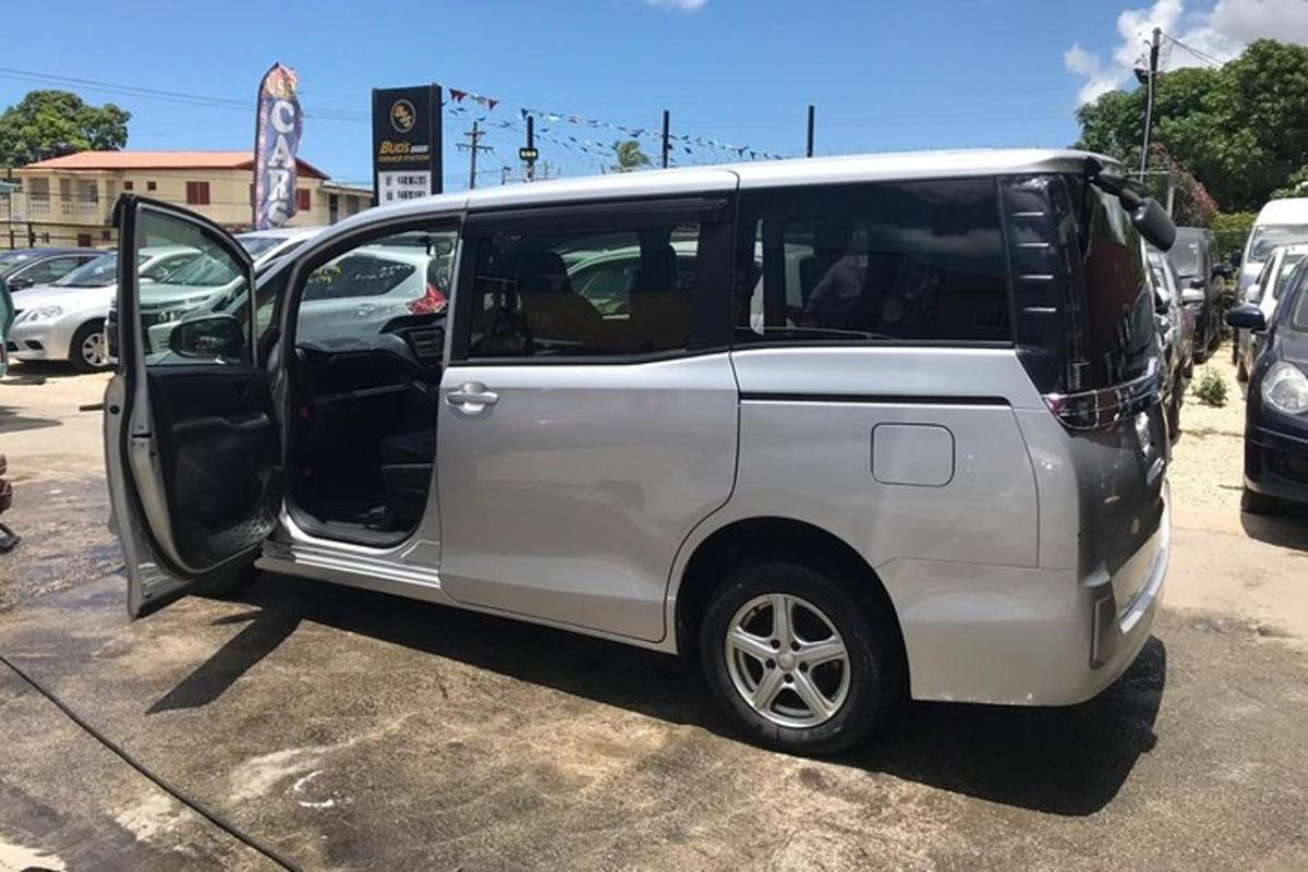 Una camioneta blanca con la puerta abierta en un estacionamiento