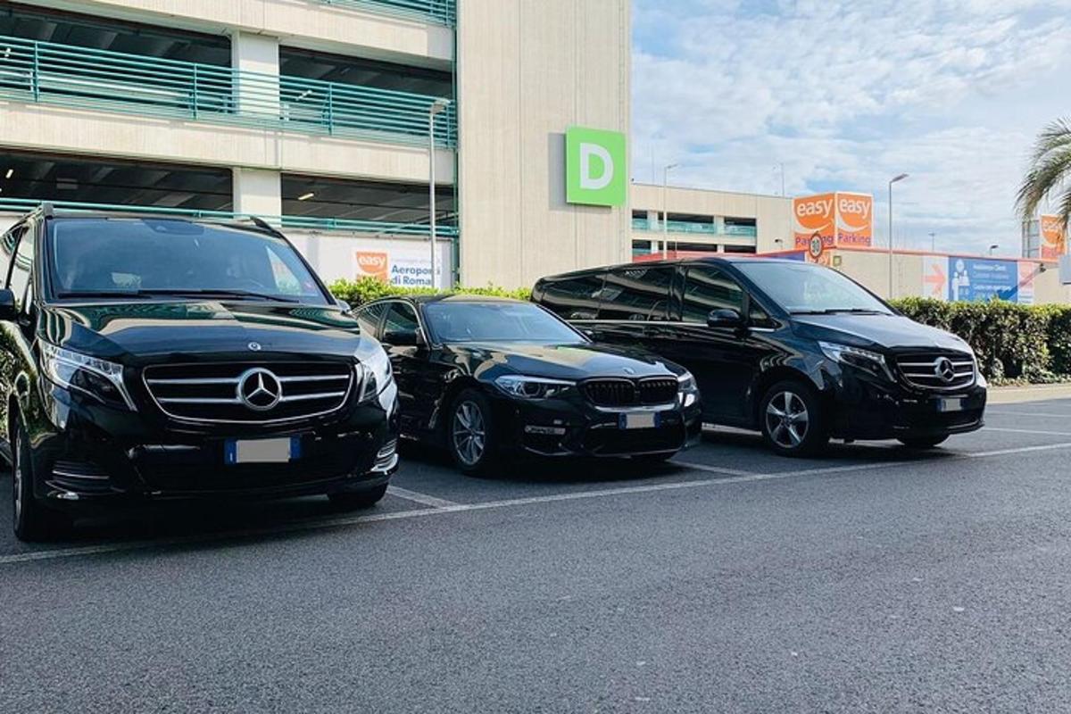 drie auto's geparkeerd op een parkeerplaats voor een gebouw