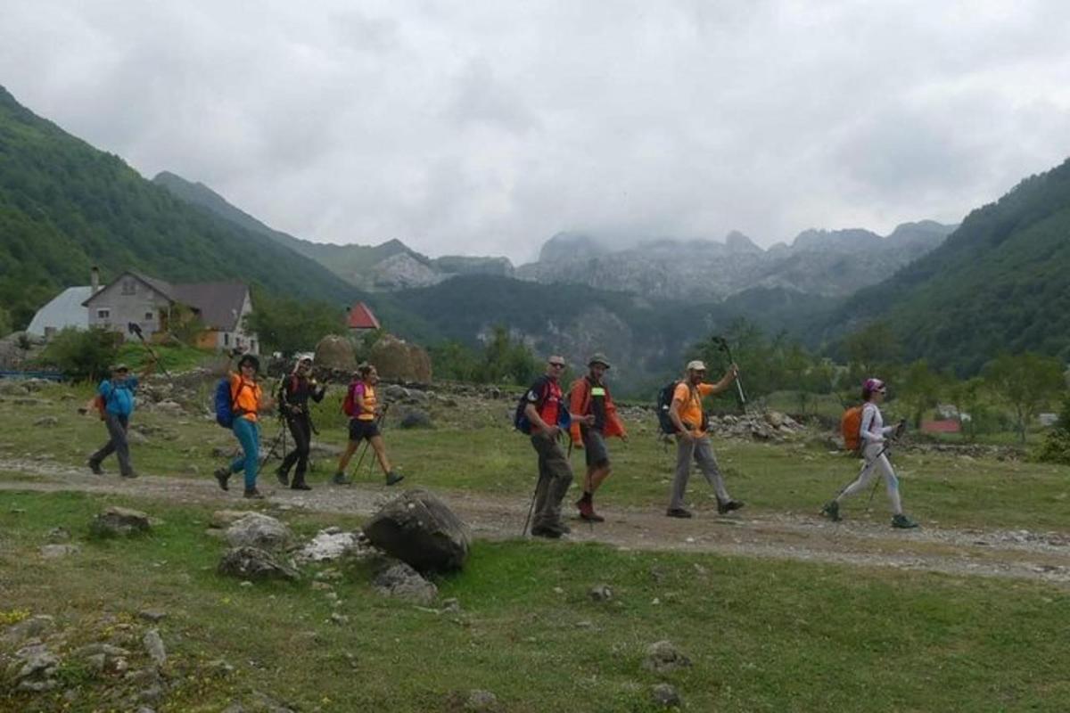 μια ομάδα ανθρώπων που περπατούν σε έναν χωματόδρομο