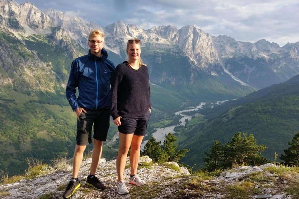 um homem e uma mulher em pé no topo de uma montanha