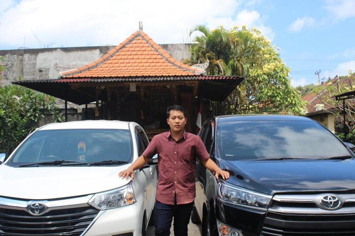 a man is standing next to two cars