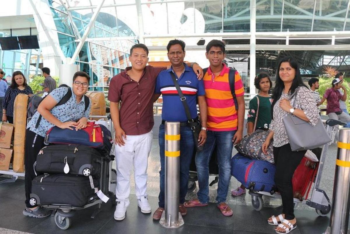 a group of people standing in an airport with luggage