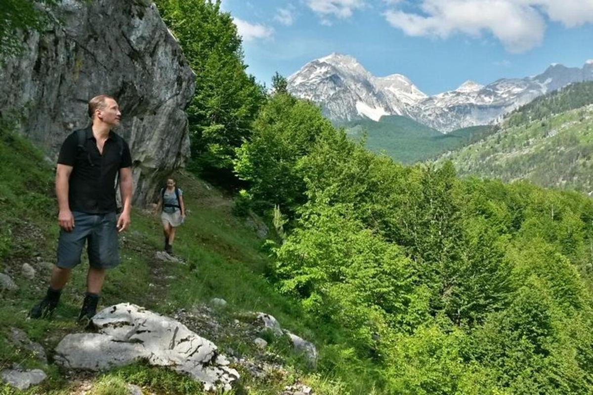 due persone che camminano su un sentiero di montagna con le montagne sullo sfondo