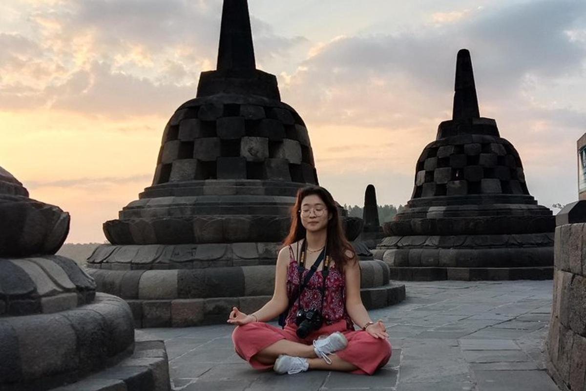 en kvinne som sitter i meditasjon foran et tempel