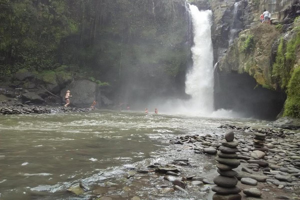 a waterfall and a stack of rocks in front of a river